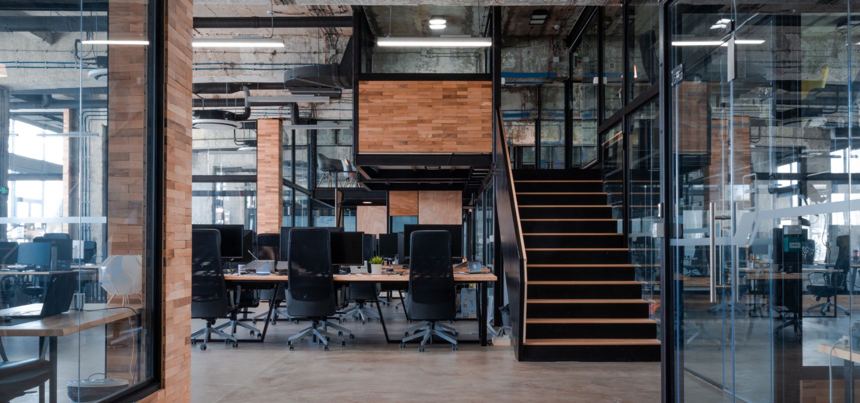 The DevAcrobats office at Puzl in Sofia — an open-plan workspace with exposed brick and a central staircase